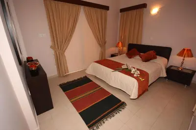 a bedroom with a bed with red pillows and a rug at Luxury Villa Rental, Two Bedroom Villa with private pool and garden, in Pissouri