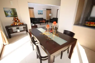 a dining room with a table and a living room at Luxury Villa Rental, Two Bedroom Villa with private pool and garden, in Pissouri