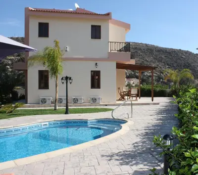 a villa with a swimming pool in front of a house at Luxury Villa Rental, Two Bedroom Villa with private pool and garden, in Pissouri