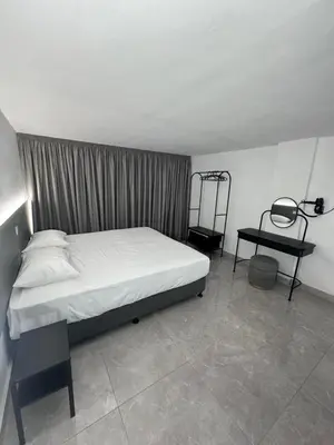 a bedroom with a bed and a side table at SeaCity Stays in Larnaka