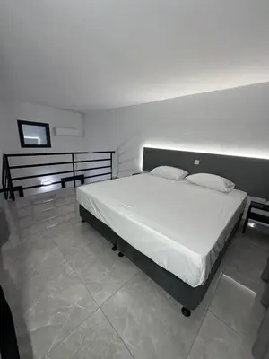 a bedroom with a large bed with white sheets and pillows at SeaCity Stays in Larnaka