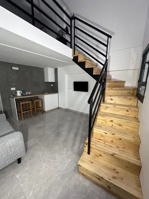 a staircase in a loft with a living room at SeaCity Stays in Larnaka
