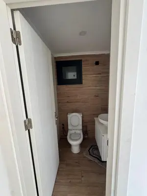 a bathroom with a toilet and a tv on the wall at 3 bed flat in Nicosia in Nicosia