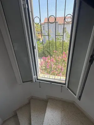 a window with a view of a garden with pink flowers at 3 bedroom Villa in Kyrenia, 2 minutes away from the beach! in Strovolos