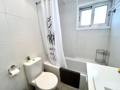 a white bathroom with a toilet and a sink at STAY Sun Line Apartment in Nicosia