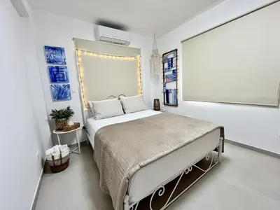 a bedroom with a bed and a large window at STAY Blue House in Larnaka