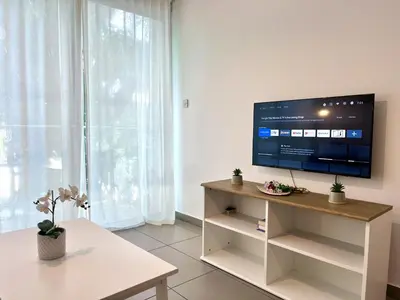 a living room with a flat screen tv on a white wall at STAY Tropical Apartment in Protaras