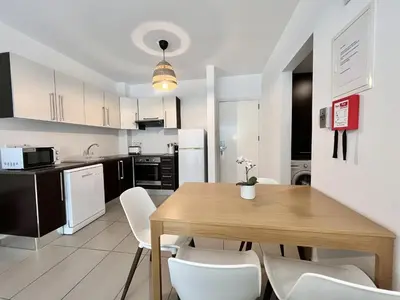 a kitchen and dining room with a wooden table and chairs at STAY Tropical Apartment in Protaras