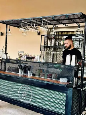 a man standing behind a counter in a restaurant at Epavli Papadopoulou - Luxury Villa - Pool & Garden in Kornos