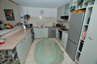 a kitchen with white appliances and a rug on the floor at Villa Acanthus in Pissouri
