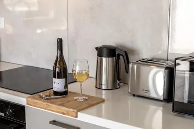 a bottle of wine and a glass on a counter at Protaras Hestia Seaside Villa A6 in Protaras