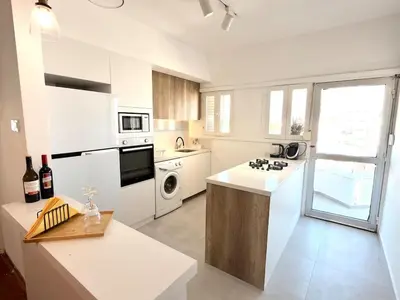 a white kitchen with a sink and a stove at The Perfect Lefkosa Stay - Zahra & Dereboyu & Ledra in Nicosia