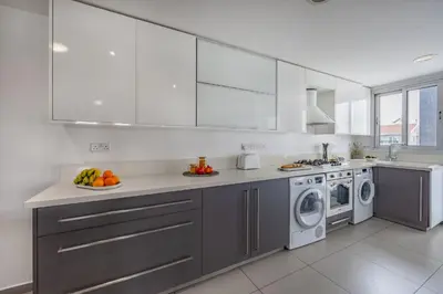 a kitchen with white cabinets and a washing machine at Vasileos Konstantinou Modern 2BR City Apartment with Balcony in Limassol