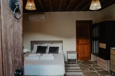 a bedroom with a white bed with two pillows at Stonehouse in Monagri