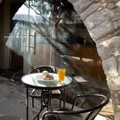 a table with a plate of food and a glass of orange juice at Stonehouse in Monagri