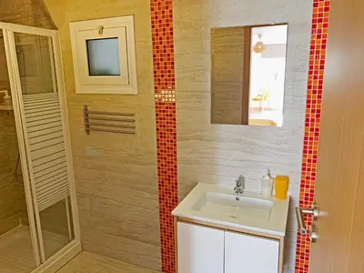a bathroom with a sink and a mirror and a shower at Rainbow Apartments in Ayia Napa