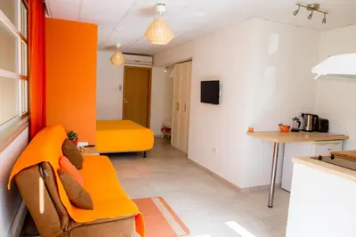 a living room with a yellow couch and a kitchen at Rainbow Apartments in Ayia Napa