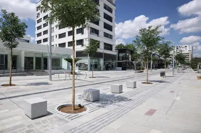 a plaza with trees and benches in front of a building at Stasikratous Residence - 10th Floor Gym in Nicosia
