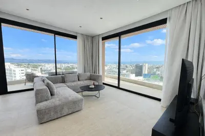 a living room with a couch and large windows at Stasikratous Residence - 10th Floor Gym in Nicosia