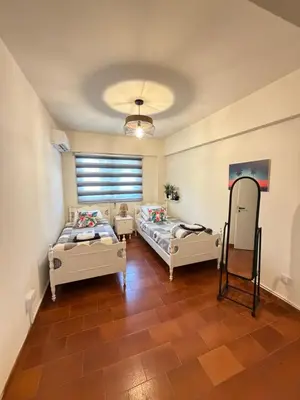 a room with two beds and a mirror at SeaScape Eight in Larnaka