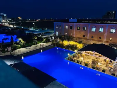 a large blue swimming pool at night at Sea view Remus Family 2 bdr apartment in Nicosia