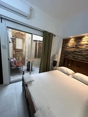 a bedroom with a large bed and a large window at Kipros Accommodation in Nicosia