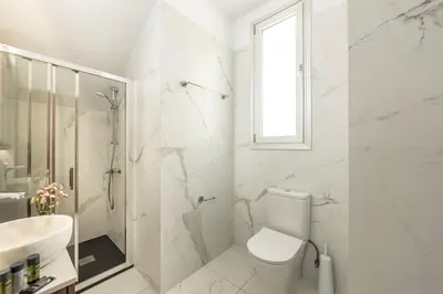 a white bathroom with a toilet and a sink at Protaras Sol e Mar Villa 2 in Protaras
