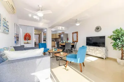 a living room with a couch and chairs and a tv at Nissi Apartment #101 in Ayia Napa