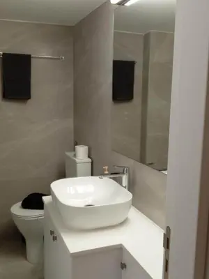 a white bathroom with a sink and a toilet at Spacious Dasoudi Beach Apt 3br in Limassol