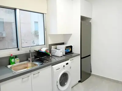 a kitchen with a sink and a washing machine at Spacious Dasoudi Beach Apt 3br in Limassol