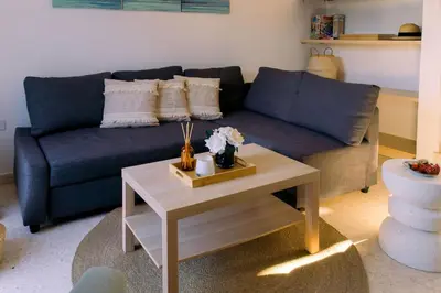 a living room with a blue couch and a coffee table at Kymo Fig Tree Bay House in Protaras