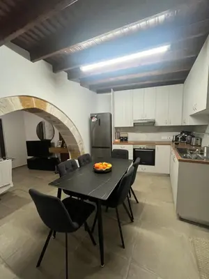 a kitchen with a table and chairs in a room at Το Αρχοντικόν in Ayvaryara