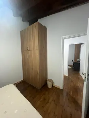 a bedroom with a bed and a wooden cabinet at Το Αρχοντικόν in Ayvaryara