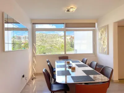 a dining room with a table and chairs and a window at Marina Sea Breeze Apartment, Sleeps 8, Free Wi-Fi in Limassol