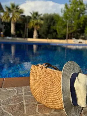 a straw hat sitting next to a swimming pool at NISSI Elena BEACH apt in Ayia Napa