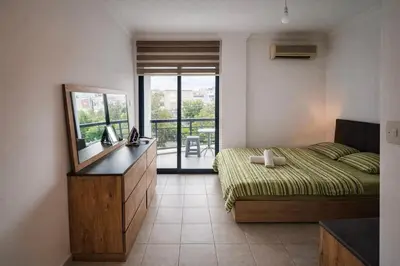 a bedroom with a bed and a mirror and a balcony at Girne KKTC in Anayia