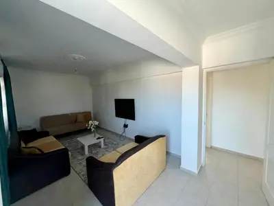 a living room with a couch and a tv at Girne KKTC in Anayia