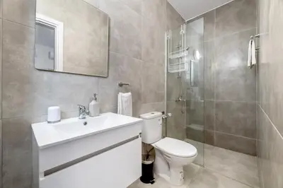 a bathroom with a toilet and a sink and a shower at Rons House in Paralimni
