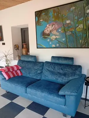 a blue couch in a living room with a painting at Ζεν σπίτι in Limassol