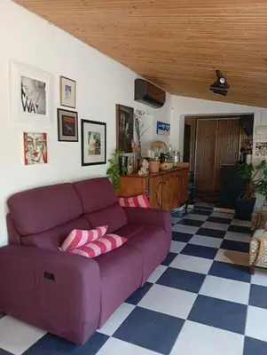 a living room with a purple couch and a checkered floor at Ζεν σπίτι in Limassol