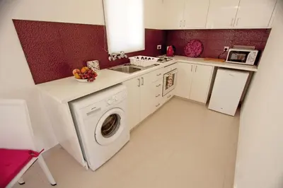 a kitchen with a washing machine and a sink at The Love Nest in Pissouri