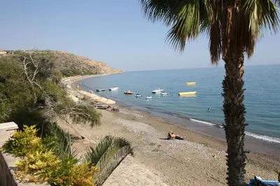 a beach with people and boats in the water at The Love Nest in Pissouri