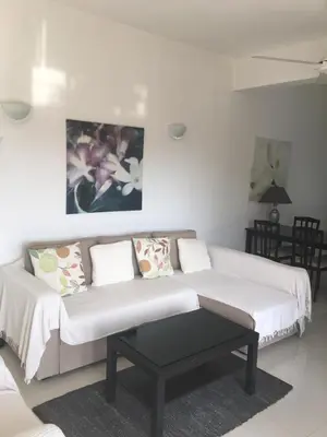 a white living room with a couch and a table at Orchard View Cottage in Maroni