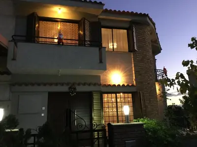 a woman sitting on the balcony of a house at night at Nikola's House in Limassol