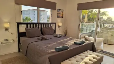a bedroom with a large bed and a balcony at Nissi Golden Sands Paradi in Ayia Napa