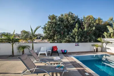 a patio with chairs and a swimming pool at Flouressia Villa 4 in Protaras