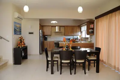 a kitchen and dining room with a table and chairs at Bay Villas in Pissouri