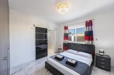 a bedroom with a large bed and a window at Protaras Villa Hollywood in Protaras