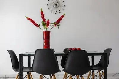 a dining room table with chairs and a vase with flowers at Protaras Villa Hollywood in Protaras