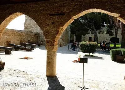 a stone archway with people walking in a courtyard at Ithaki Phinikoudes Apartment 307 in Larnaka
